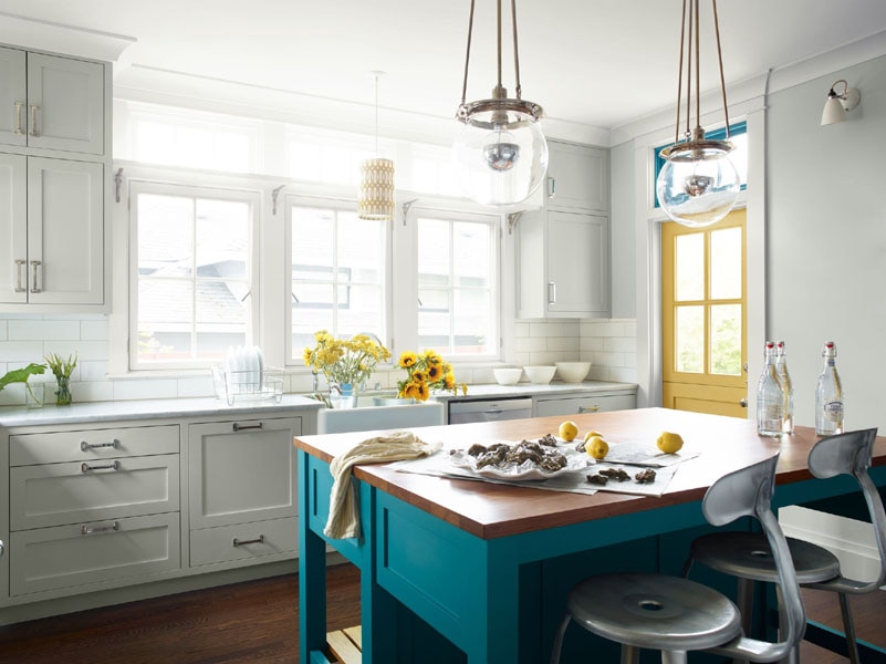 A kitchen with a central island painted in Caribbean Blue Water 2055-30. The wall cabinets feature Gray Owl 2137-60 and the back door is painted in Marblehead Gold HC-11