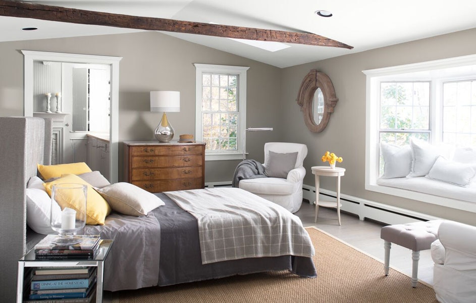 A bedroom with window seat and exposed wooden beams.  The walls are painted in Silver Fox 2108-50 and the woodwork and ceiling are painted in Chantilly Lace 2121-70.