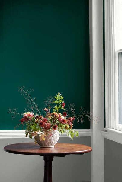 A hallway vignette featuring Hunter Green 2041-10 above the dado rail and Coventry Gray HC-168 below with woodwork and dado painted in White Heron OC-57.