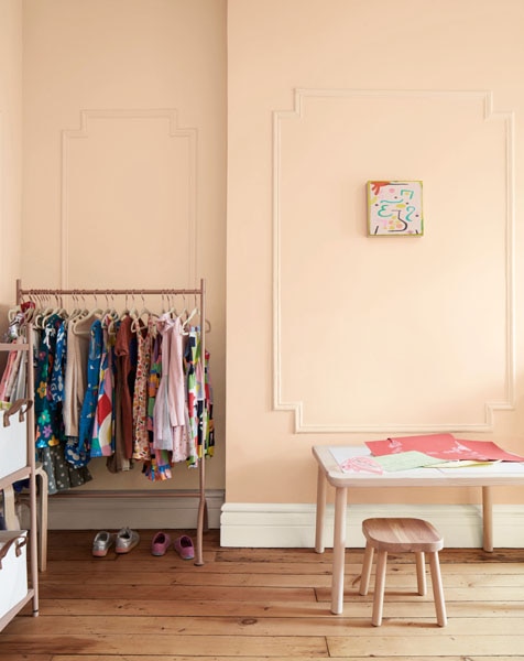 A child's dressing area and desk with panelled walls painted in Tissue Pink 1163 and woodwork painted in Glacier White OC-37.