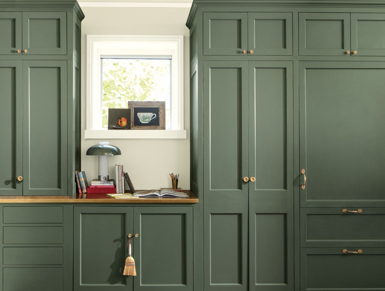 A wardrobe and dressing table painted in Rosepine 461 and walls painted in Paris Rain 1501. The dressing table is style with books and a lamp.