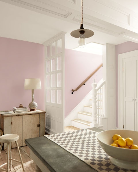An open-plan kitchen with view to a staircase. Walls are painted in Batik AF-610 and woodwork and doors are painted in Swiss Coffee OC-45.